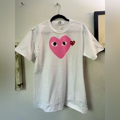 100% Cotton Made In Japan Authentic Play Shirt Could Fit Women’s Size Large To Semi Xl Heart Graphic With Striking Black Eyes Adorn Tee Crewneck Short Sleeves Pullover Style About 27" From Shoulder To Hem Cotton Hand Wash Imported The Signature Red Heart, Complete With Instantly Recognizable Wide Eyes, Is Emblazoned On Solid T-Shirts, Knitwear And Sneakers. White Cotton T-shirt With Heart Patch, Cotton Streetwear Top With Heart Shape, Cotton Heart-shaped Top For Streetwear, Casual Cotton T-shirt With Heart Patch, White Crew Neck Top With Heart Patch, Casual White T-shirt With Heart Print, Casual White T-shirt With Heart Shape, White Casual Top With Heart Patch, Casual White Top With Heart Patch