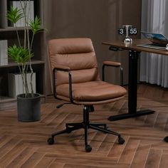 a brown leather office chair sitting in front of a desk with a laptop on it