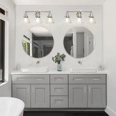 a bathroom with double sinks and two mirrors on the wall next to a bathtub