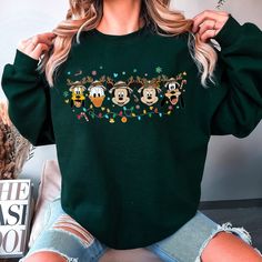 Disney Christmas Sweatshirt, Disney Letter Print Sweatshirt For Winter, Animal Kingdom Christmas Shirts, Disney Green Crew Neck T-shirt, Disney Graphic Print Top For Winter, Disney Graphic Print Tops For Winter, Casual Christmas Sweatshirt With Cartoon Print, Christmas Long Sleeve Tops With Character Print, Casual Green Christmas Sweatshirt