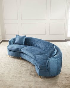 a blue couch sitting on top of a carpeted floor next to a white wall