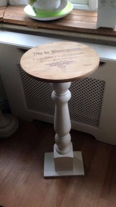 a small wooden table sitting in front of a window