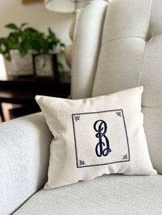 a pillow with the letter b on it is sitting on a couch in front of a chair