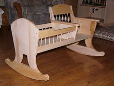 a wooden rocking chair sitting on top of a hard wood floor next to a couch