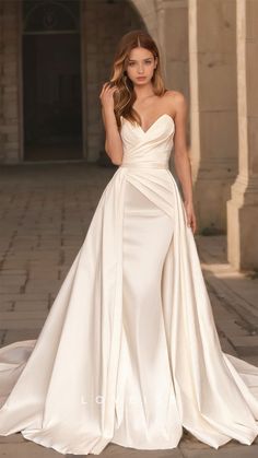 a woman in a white wedding dress posing for the camera with her hand on her hip