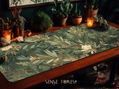 a wooden table topped with plants and candles