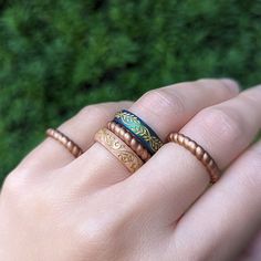 a person holding two different rings in their hand with grass behind them and green grass