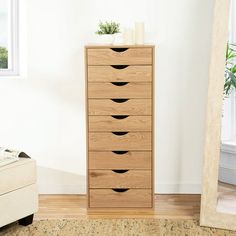 a wooden dresser sitting next to a window in a room with a rug on the floor