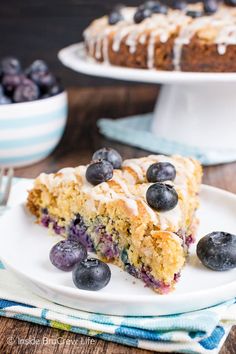 a slice of blueberry coffee cake on a plate next to a bowl of blueberries