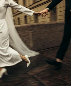 the bride and groom are running down the street