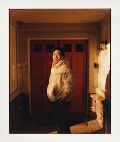 a woman standing in front of a red door