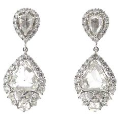 These exquisite vintage earrings are a masterpiece of craftsmanship, featuring a total of 5.14 carats of IGI certified rose-cut diamonds. The design boasts an elegant dangle structure, crafted in what appears to be platinum or white gold, emphasizing the diamonds' natural brilliance. Each earring consists of two parts: the upper portion houses a smaller teardrop-shaped diamond framed by a delicate halo of round diamonds, while the lower part features a larger, marquise-shaped rose-cut diamond, also encircled by a sparkling halo. These main stones are artfully connected by a slender strand of diamonds, allowing for graceful movement. The intricate setting enhances the diamonds' visibility, making them the focal point and ensuring they catch the light with every turn. These earrings embody t Bridal Accessories Jewelry, Celebrity Wedding, Bridal Fashion Jewelry, Modern Glam, Wedding Accessory, Bride Earrings, Diamond Dangle Earrings, Wedding News, Bridal Inspo