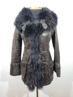 Wonderful women's warm sheepskin coat with genuine fur. Stylish brown sheepskin coat with a wide fluffy collar. A wonderful women's sheepskin coat. The sheepskin coat is made of wonderful warm genuine brown fur. The outer side of the sheepskin coat has a surface structured like a reptile. The sheepskin coat fastens with buttons. The leather jacket has two convenient front pockets with flaps. The sheepskin coat has a wonderful wide collar made of fluffy fur. The sheepskin collar has decorative straps with metal buckles. The sleeves of the sheepskin coat are also decorated with belts with buckles. This sheepskin coat will keep you warm in cold late autumn and harsh winter. A stylish, warm and comfortable sheepskin coat will emphasize your refined appearance even in bitter cold. MEASUREMENTS: Women Leather Vest, Penny Lane Coat, Harsh Winter, Winter Overcoat, 80s Women, Black Faux Fur Coat, Late Autumn, Sheepskin Coat, Brown Fur