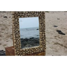 there is a mirror made out of logs on the beach