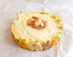 a cake with frosting and decorations on it sitting on top of a white tablecloth