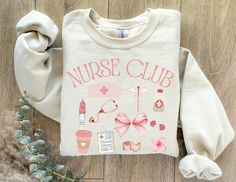 a sweater with the words nurse club on it next to some flowers and other items