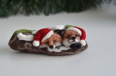 two small dogs wearing santa hats on top of a piece of felt