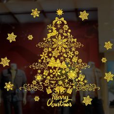 the window is decorated with gold snowflakes and christmas tree silhouettes on it