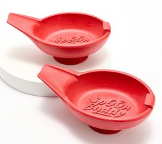 two red plastic spoons sitting on top of each other