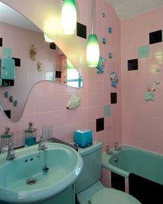 a bathroom with pink walls and black and white tiles on the wall, along with a green bathtub