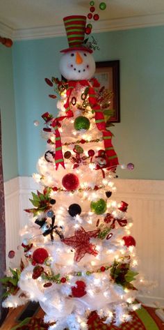 a white christmas tree decorated with red and green ornaments