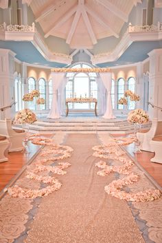 the aisle is decorated with pink flowers and white draping for an elegant wedding