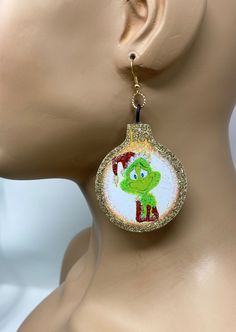 Upcycled / Repurposed  Whoville Christmas  How the Grinch Stole Cartoon Handcrafted Earrings   Statement earrings. Handmade. Measures Approx. 2.5" Long with 925 silver ear wire 3 inches long. 2½" tall  x  2" wide The weight of each earring is approx.. 15 grams. or .25 ounce Vintage die cut Image was applied to wood composition and individually hand cut, and hand glittered on one side only. These can also later be used as ornaments! We have more from this character listed. Grinch Cartoon, Der Grinch, Le Grinch, Santa Cap, Whoville Christmas, The Grinch Stole Christmas, Grinch Stole Christmas, Cut Image, The Grinch