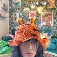 a crocheted hat with ears on top of a mannequin's head