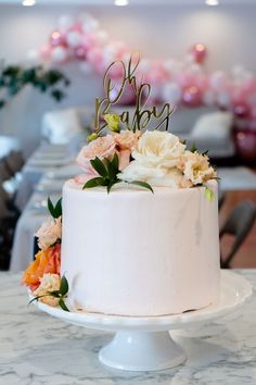 White and Pink It's a Girl Baby Shower. Pink, peach and white flower centerpieces created by Anthesis Co. White and Pink balloon arch. White and Gold table set. Hair scrunchie party favors. Light pink cake with oh baby sign. White Baby Showers