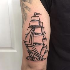 a man's arm with a black and white tattoo of a ship on it