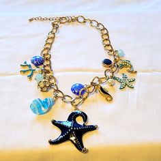 Fashion Goldtone 16" With 3" Extender Beach Wear Necklace With Glass Beads, Sea Horse, Dolphin, Coral, And Blue Starfish Charms. Never Worn Blue Starfish Charm Jewelry For Summer, Adjustable Blue Necklace With Starfish Charm, Blue Summer Jewelry With Starfish Charm, Summer Blue Starfish Charm Jewelry, Ocean-inspired Blue Beaded Necklace With Colorful Beads, Ocean-inspired Blue Beaded Necklace, Blue Strand Necklaces For Beach Season, Blue Costume Jewelry Necklaces With Lobster Clasp, Ocean-inspired Blue Jewelry With Colorful Beads