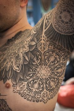 a man with tattoos on his chest and arm