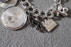 I am offering you this spectacular vintage sterling silver (stamped) mixed themed charm bracelet. This is a loaded charm bracelet having 15 unique mixed theme charms . It is on a classic wide multi leveled linked charm bracelet , the previous owner had several years of collecting here !! There are several that have enameling. It measures app. 7.25 inches long , and is app. 1.5 inches at it widest dangle point. It weighs app. 43 grams. This was a wonderful estate find from here in upstate new Yor Silver Charm Bracelet With Vintage Charm As A Gift, Silver Vintage Charm Bracelet Gift, Silver Engraved Charms For Collectors, Collectible Silver Engraved Charms, Nickel-free Silver Charms Souvenir, Nickel-free Silver Charms For Souvenir, Silver Charm Bracelet As Souvenir, Silver Charms Jewelry Souvenir, Silver Engraved Charm Bracelet