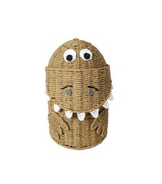 a wicker basket with eyes and mouth on it's side, in front of a white background