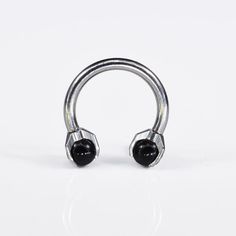 a pair of black stone nose rings on a white background