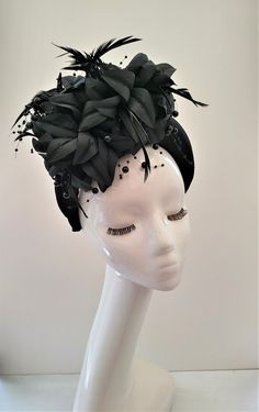 Presenting a stunning beautiful black fascinator with feathers and beading, attached via a  black velvet  covered headband  which is 4 cms in width at the widest part approximately and 3.5 cms in height (the headband) the feather flower design is much higher above the design. Perfect for special events.  If you would like the design customising at all, or an alternate colourway please get in touch with me and I will be delighted to help.   Follow us on instagram: https://www.instagram.com/designbyhummingbirdofficial/ Adjustable Round Crown Fascinator For Parties, Black Spring Fascinator Headband, Elegant Headband Fascinator For Costume Party, Evening Fascinator With Handmade Flowers And Adjustable Fit, Handmade Flowers Adjustable Fascinator For Evening, Evening Fitted Headpiece With Handmade Flowers, Elegant Headpieces For Kentucky Derby Costume Party, Black Headband Costume Hats For Spring, Elegant Adjustable Headpieces For Costume Party