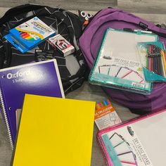 several school supplies are laid out on the floor next to each other, including notebooks and pens