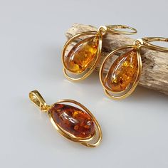 Brown amber set. Beautiful natural cognac Baltic Amber SET (Earrings + Pendant). Handmade of brown Baltic Amber. Gold plated - with hallmarks. Weight: pendant 2,54 gr Earrings 5,63 gr Length: pendant size 3,5 x1,6 cm , Earrings length 4 cm Matching ring: https://www.etsy.com/uk/listing/932778160/amber-ring-gold-plated-ring-natural?ref=shop_home_active_16&pro=1&frs=1 This item was made of natural Baltic Amber. All the amber used in my jewelry is collected in my home country Lithuania. I sell only Amber Ring Gold, Small Gold Earrings, Set Earrings, Amber Pendant, Matching Ring, Crystal Healing Stones, Amber Earrings, Amber Ring, Earrings Pendant