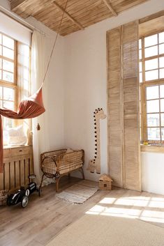 a room with wood floors and white walls, including a hammock bed in the corner