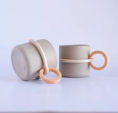 two cups with rings on them sitting next to each other in front of a white background