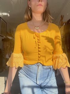 "Absolutely gorgeous 1960s blouse made of bright marigold yellow cotton with big crocheted sleeves. Buttons up along the front and ties in a bow at nape of neck. Fitted, slightly cropped. * Great condition, no flaws to note other than slight wear to some of the button loops Shoulders: 15\" Bust: 35\" Waist: 30\" Length: 17\" Armscye: 18\" Suggested sizing: small to medium ---- All vintage items have been described and dated to the best of my ability. With this said, all dates are approximations Cheap Yellow Vintage Blouse, Affordable Yellow Vintage Blouse, Yellow Striped Dress, Yellow Knit Sweater, Marigold Yellow, Yellow Blazer, Yellow Scarf, Floral Cotton Dress, Yellow Knit