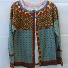 a cardigan sweater hanging on a white wall with a blue and brown color scheme