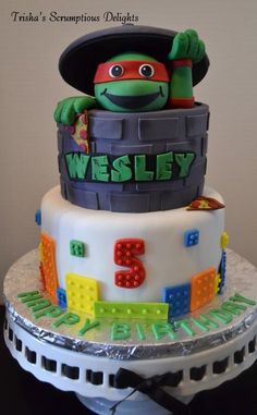 a birthday cake made to look like a lego ninja turtle sitting on top of a barrel