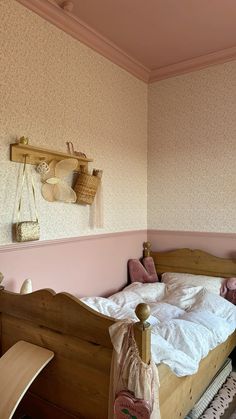 a bedroom with pink walls and white bedding