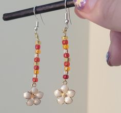 Red and gold beads white daisy flower charms drop dangle ear wire earrings Red Beaded Flower Shaped Jewelry, Red Beaded Dangle Flower Earrings, Gold Flower Earrings With Dangling Beads As Gift, Gold Flower-shaped Earrings With Dangling Beads, Gold Flower-shaped Jewelry With Dangling Beads, Red Dangle Flower Earrings With Colorful Beads, Red Dangle Earrings With Flower Charm, Red Flower Beaded Earrings With Dangling Beads, Red Drop Earrings With Flower Charm