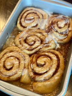 cinnamon rolls in a baking dish with icing drizzled on top