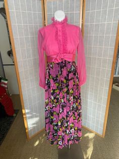 Awesome 1970’s hot pink maxi dress with pink flowers on black skirt. Long sheer sleeves, zipper up the back. One small stain on bust, rip in chiffon under one arm, and lighting discolored underarms inside the dressBust: 35/36”Waist: 28”Hips: 38”Skirt length: 38.5” Pink Maxi Dress For Spring Evening, Vintage Maxi Dress For Dress Down In Spring, Pink Long Sleeve Maxi Dress For Casual Wear, Pink Maxi Dress For Fall, Pink Ruffled Maxi Dress For Fall, Fall Flowy Pink Maxi Dress, Flowy Pink Maxi Dress For Fall, Pink Floor-length Maxi Dress For Fall, Pink Floor-length Fall Dress