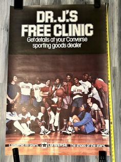 a poster hanging on the side of a wall with basketball players and their coach in it