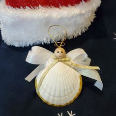 an ornament shaped like a shell with a little angel on it's back