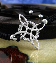 a black cord bracelet with an intricate design on it